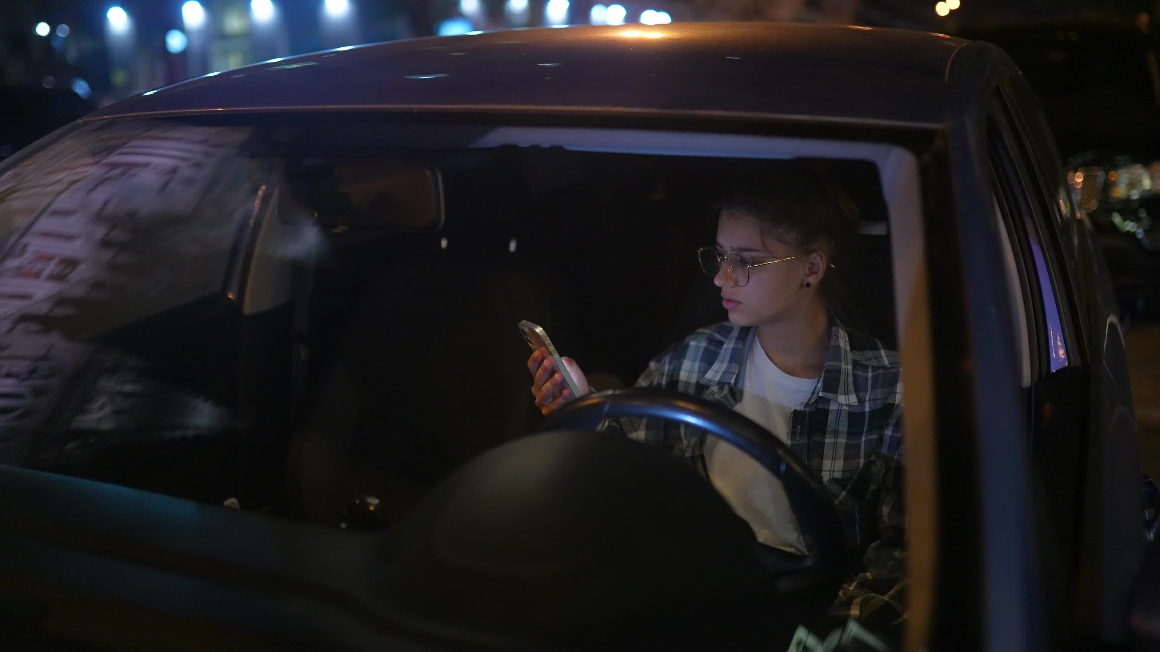 Girl Sitting In Parked Car Using Smartphone At Night 11482933 Stock girl-sitting-in-parked-car-using-smartphone-at-night-11482933-stock