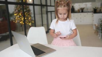 poco ragazza utilizzando computer a casa con famiglia video