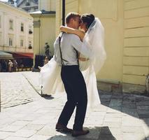 groom carries bride in his arms photo