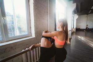 Active sportive woman stretching, young woman helping her photo