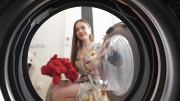 Visualizza di dentro il asciugatrice come donna si asciuga lavanderia a casa video