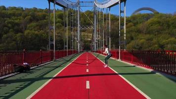 exercícios de mulher com cordas de batalha em uma ponte de pista de pedestres video