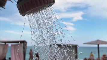 Water streams from outdoor shower by a beach video