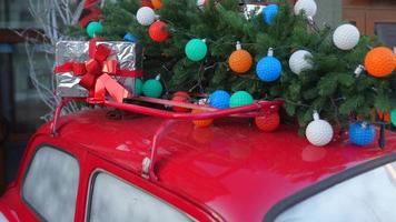 Little red car loaded up with festive holiday decorations and Christmas tree video