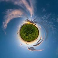 tiny planet in blue sky with beautiful clouds. Transformation of spherical panorama 360 degrees. Spherical abstract aerial view. Curvature of space. photo