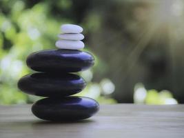 spa pila de piedra blanca y negra sobre mesa de madera, concepto de equilibrio y armonía. foto