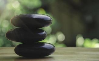 Spa black and white stone stack on wooden table, concept of balance and harmony. photo