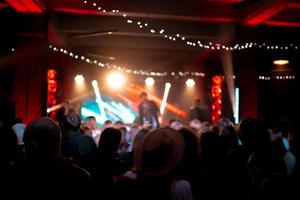 Photo of many people enjoying rock concert in nightclub