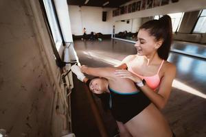 Active sportive woman stretching, young woman helping her photo