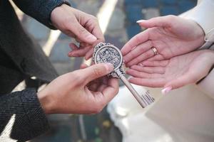 groom gives the bride a key photo