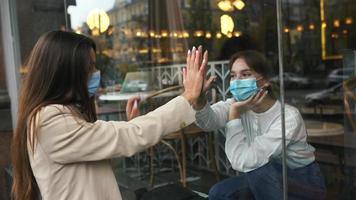 Girl friends meet and talk through window video