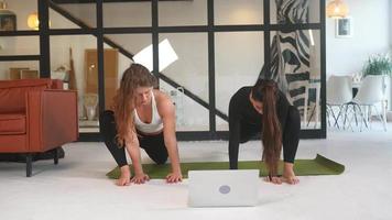 Girls doing online yoga at living room video