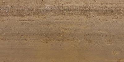 panorama of surface from above of gravel road with car tire tracks photo