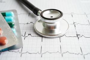 estetoscopio en electrocardiograma con droga, onda cardíaca, ataque cardíaco, informe de cardiograma. foto