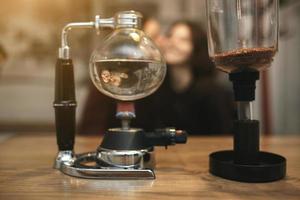 Vintage couple preparing coffee with vacuum coffee maker.Coffee shop photo