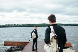 two young guys standing on a pier photo