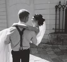 groom carries bride in his arms photo