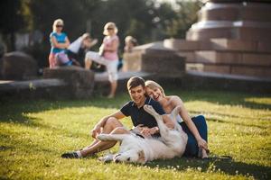 niño y niña con perro yacen en la hierba foto