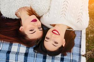 Two beautiful girls lie on the bench photo