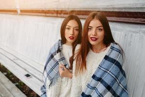 Two girls sit on a bench in the park photo