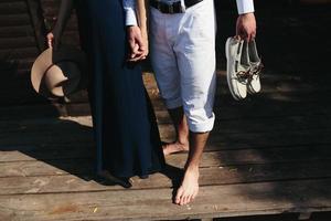 couple walk barefoot on pier photo