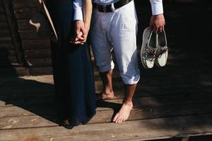 couple walk barefoot on pier photo