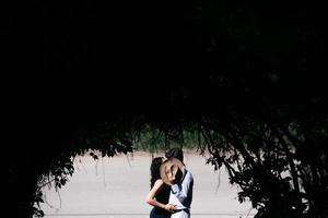 couple jumping in the end of tunnel with trees photo