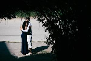 couple jumping in the end of tunnel with trees photo