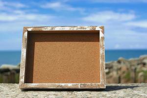 Wooden frame with blurred background of ocean. Copy space. photo