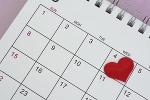 forma de corazón rojo en la fecha del cuarto día del calendario. foto
