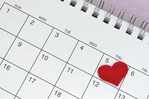 forma de corazón rojo en la fecha del quinto día del calendario. foto