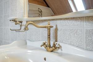 metal water tap with sink and faucet to turn on and regulate cold or hot water in expensive bathroom. photo