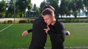 Two young men do training exercise together in outdoor field video