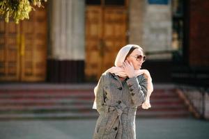 girl in a coat posing on building background photo