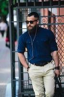 bearded man standing and listening to music photo