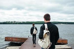 two young guys standing on a pier photo