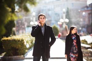 hombre de negocios hablando por teléfono mientras la mujer viene a él foto