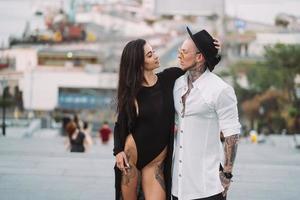 una joven y sexy pareja de amantes posan para una cámara en las calles foto