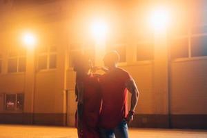 una joven pareja sexy amantes posan en la calle nocturna de la ciudad. foto