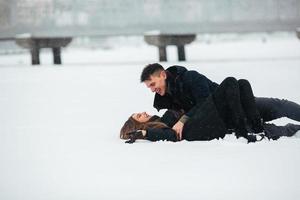 Girl and guy lie on snow photo