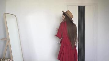 Young woman tries on clothes in front of a full length mirror in bedroom video