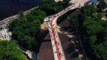 Aerial view of Kyiv pedestrian bridge over street traffic and city view of Kyiv Ukraine video