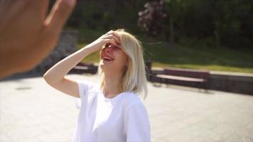 Young blonde woman or teen looks up and high fives person off camera video