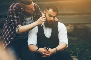 barber shaves a bearded man in vintage atmosphere photo