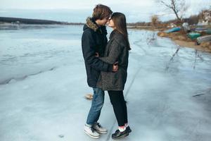 young beautiful couple on the ice of a frozen lake photo