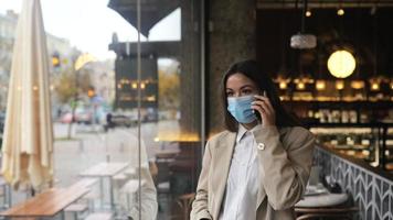 mujer habla por teléfono mirando a través de la ventana de la cafetería video