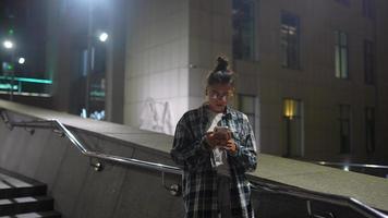 menina usando seu telefone na cidade à noite video