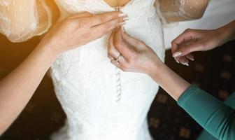 Bride putting on her dress photo