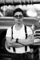 Guy in a shirt with suspenders posing at the retro car photo