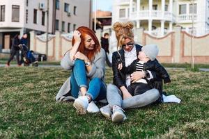 mamá y tía juegan con un niño en el parque foto